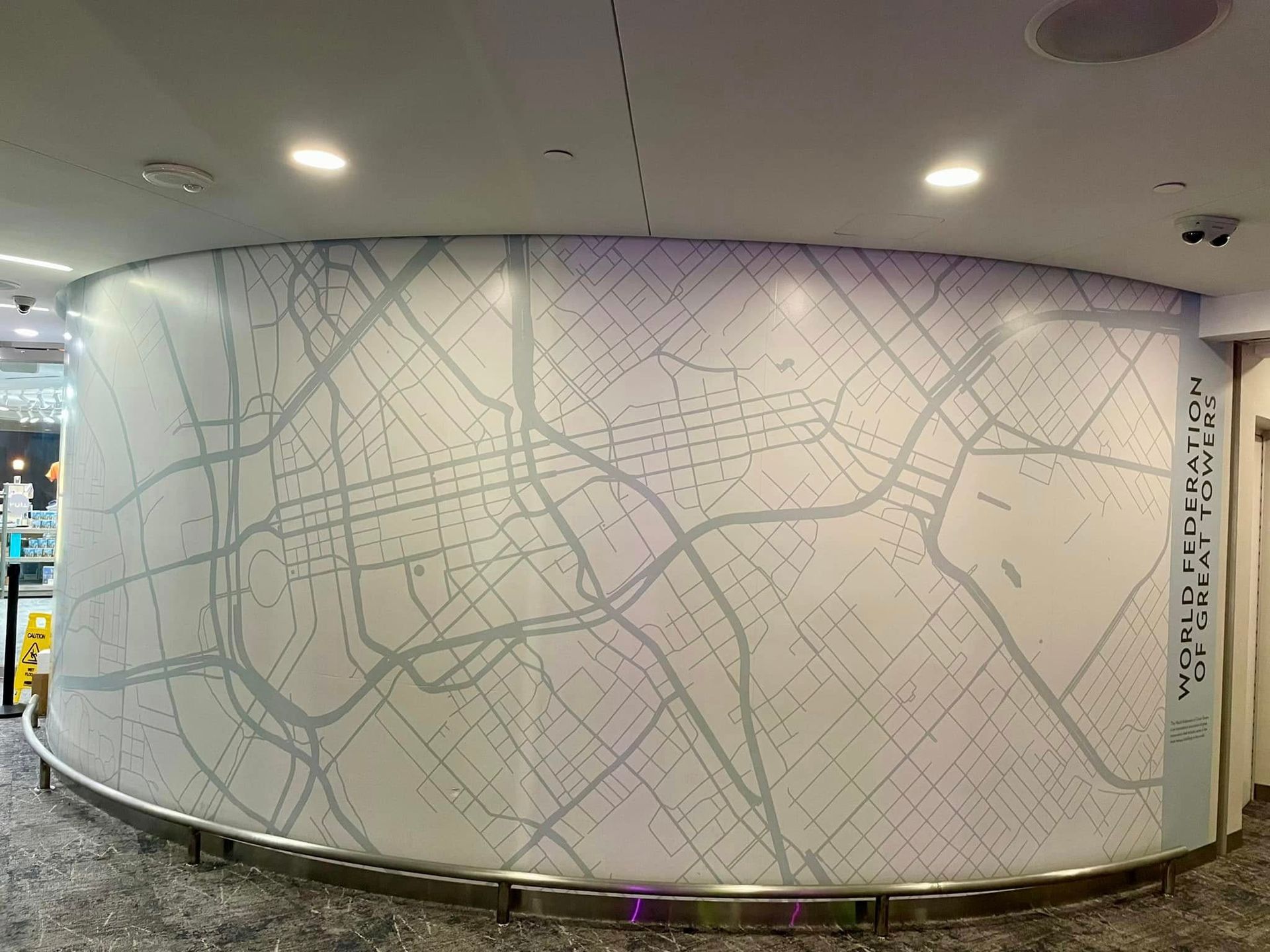 Curved mural of a city street map in a brightly lit indoor space.