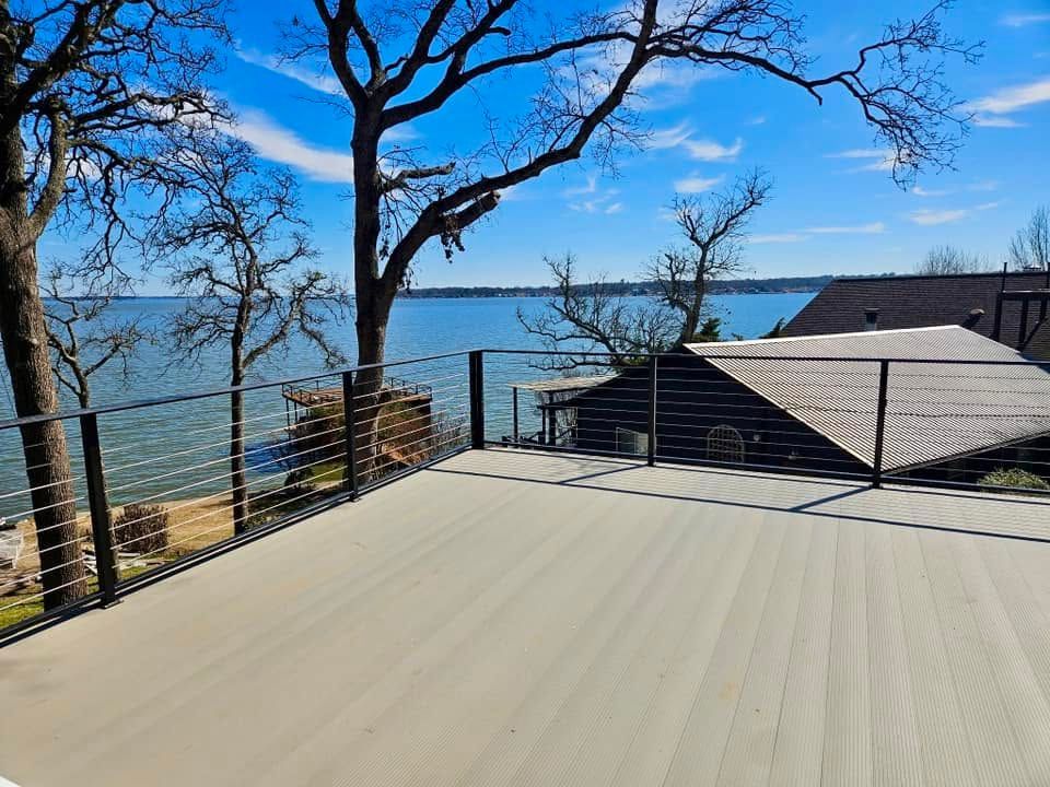 Rooftop deck with lake view, leafless trees, and clear blue sky.