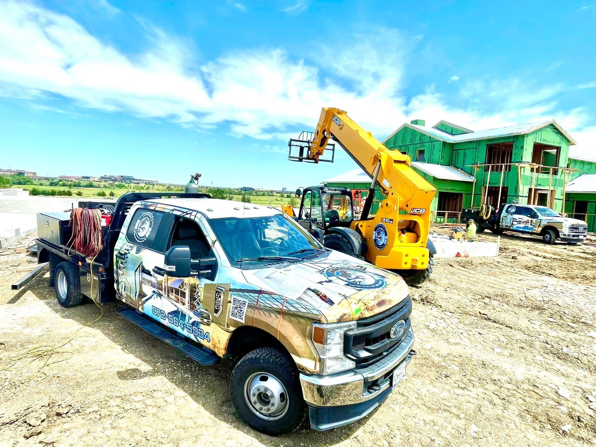 Damaged pickup truck beside a yellow excavator at a muddy construction site with a green building in the background.