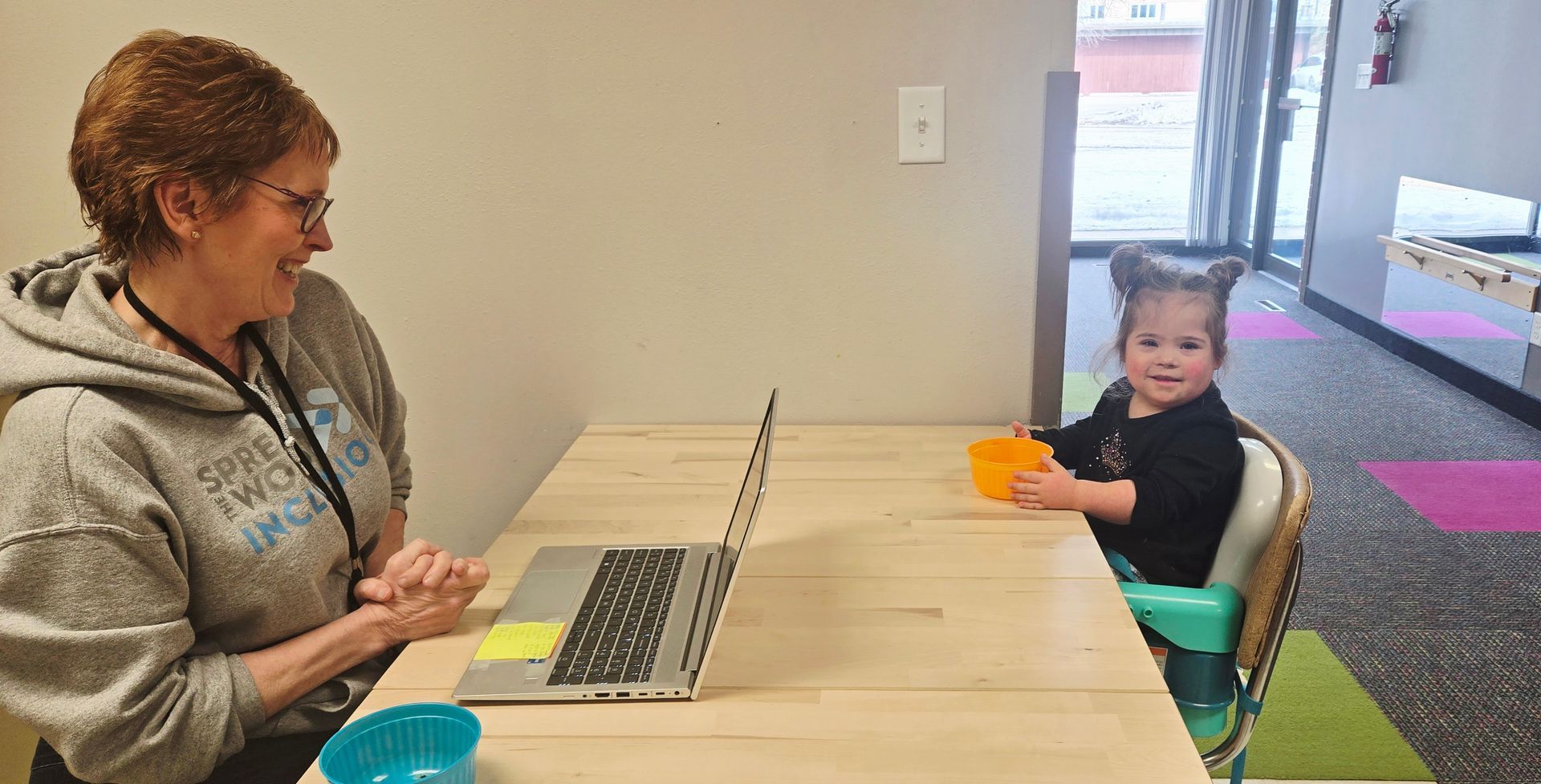 A woman is sitting on the floor with a young boy.