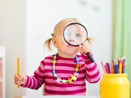 Little girl holding magnifying glass
