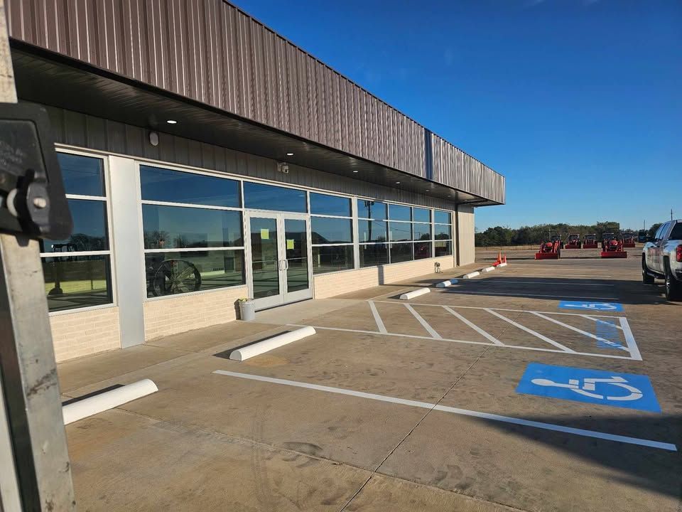 Empty storefront with accessible parking spaces and blue handicap markings under a clear sky