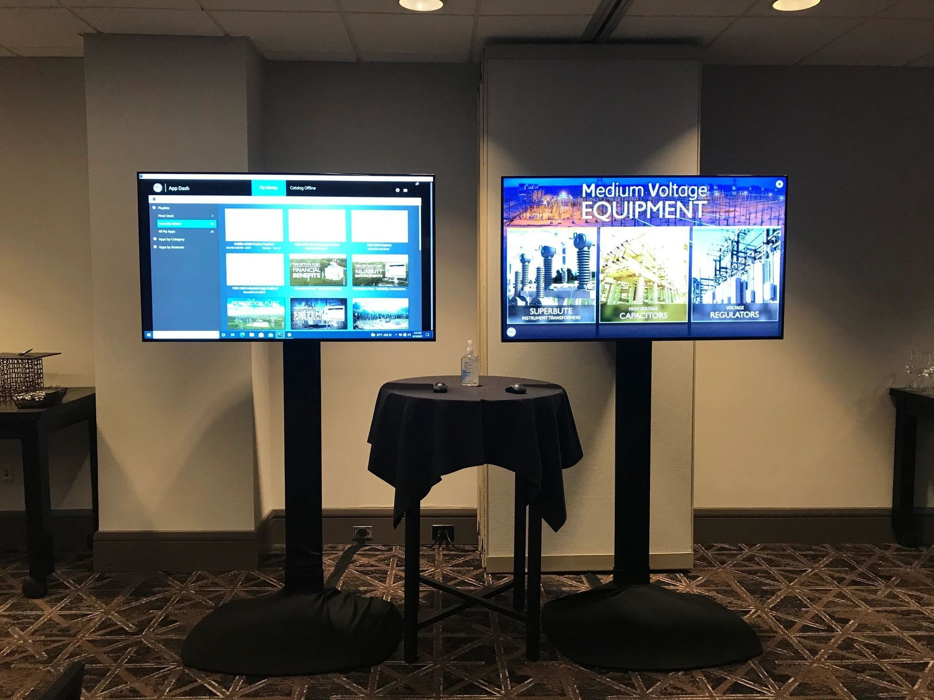 Two flat screen televisions are on stands in a room