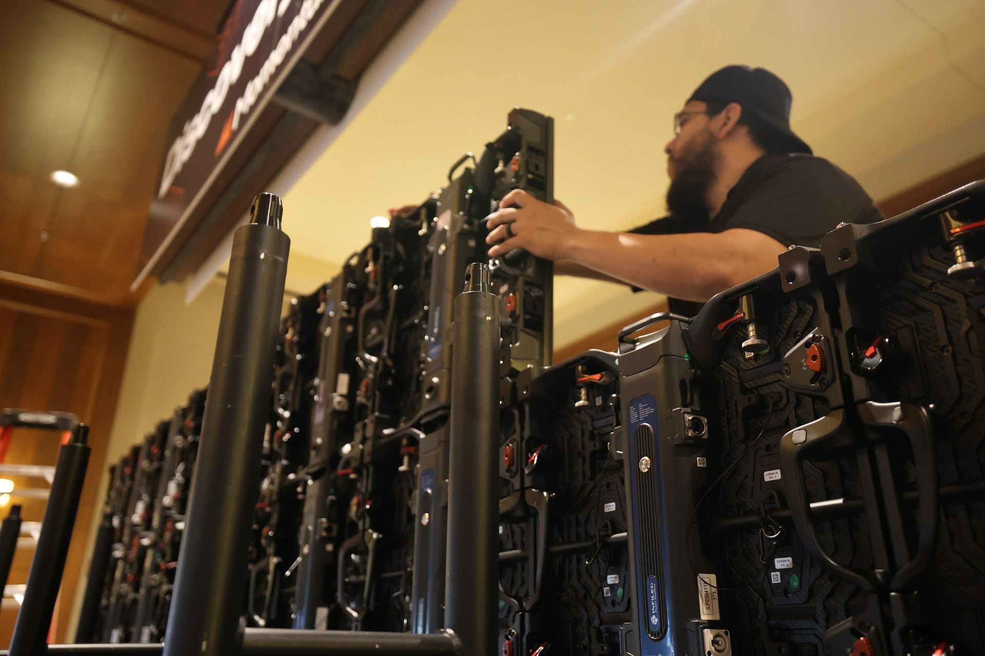 A man is working on a row of computer monitors
