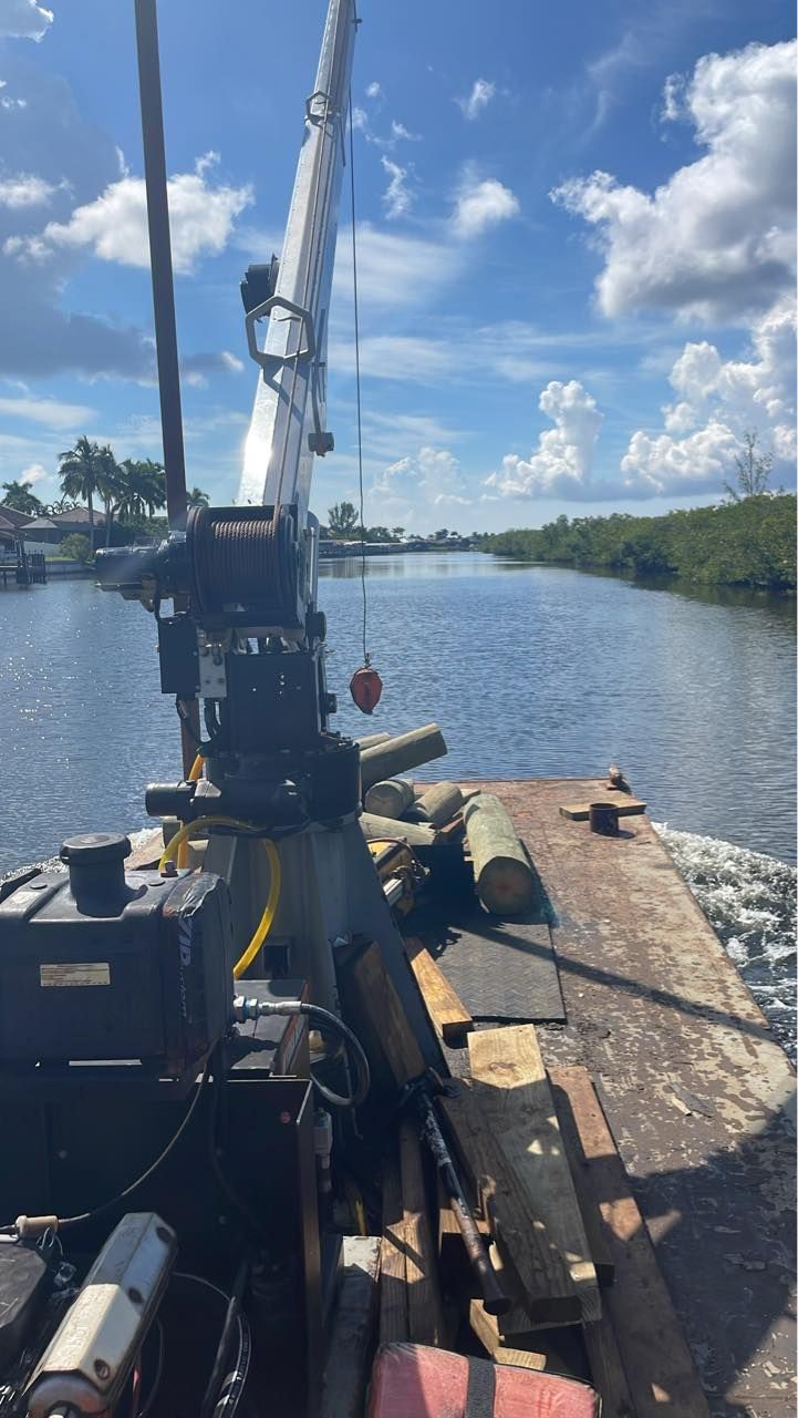 A boat with a crane attached to it is floating on top of a body of water.