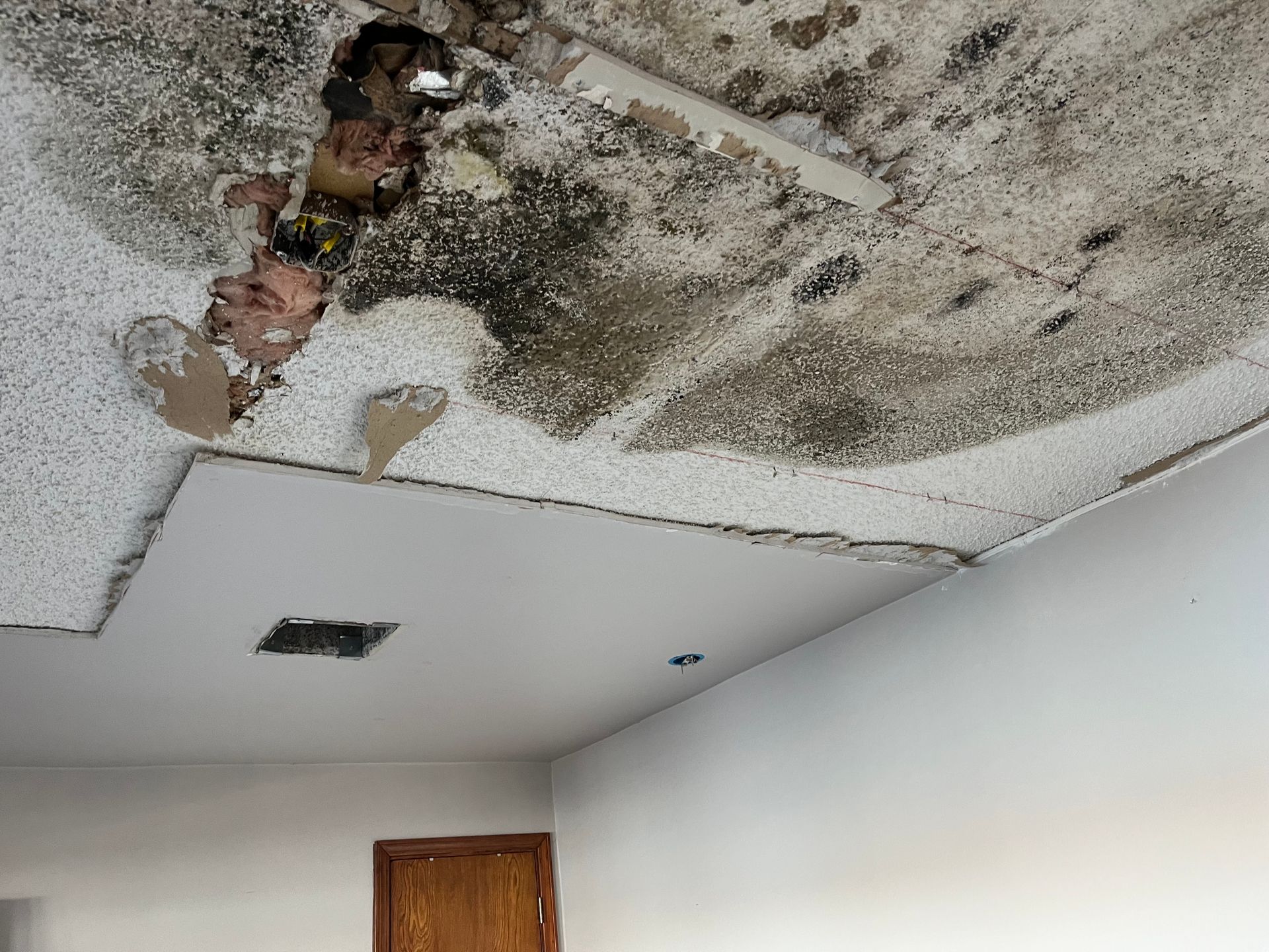 A crawl space under a house with a lot of plastic on the floor.