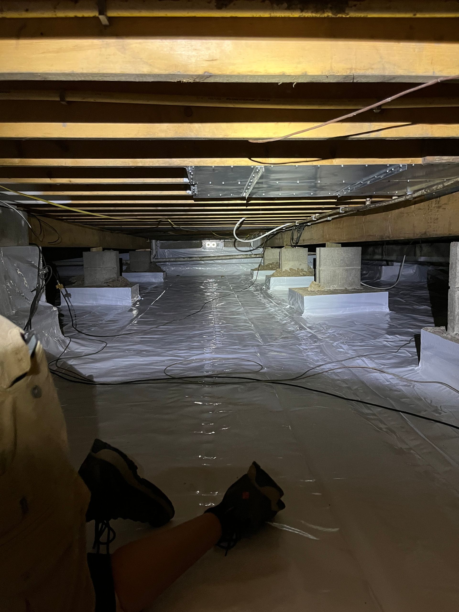 A person is standing in a basement with a flashlight.