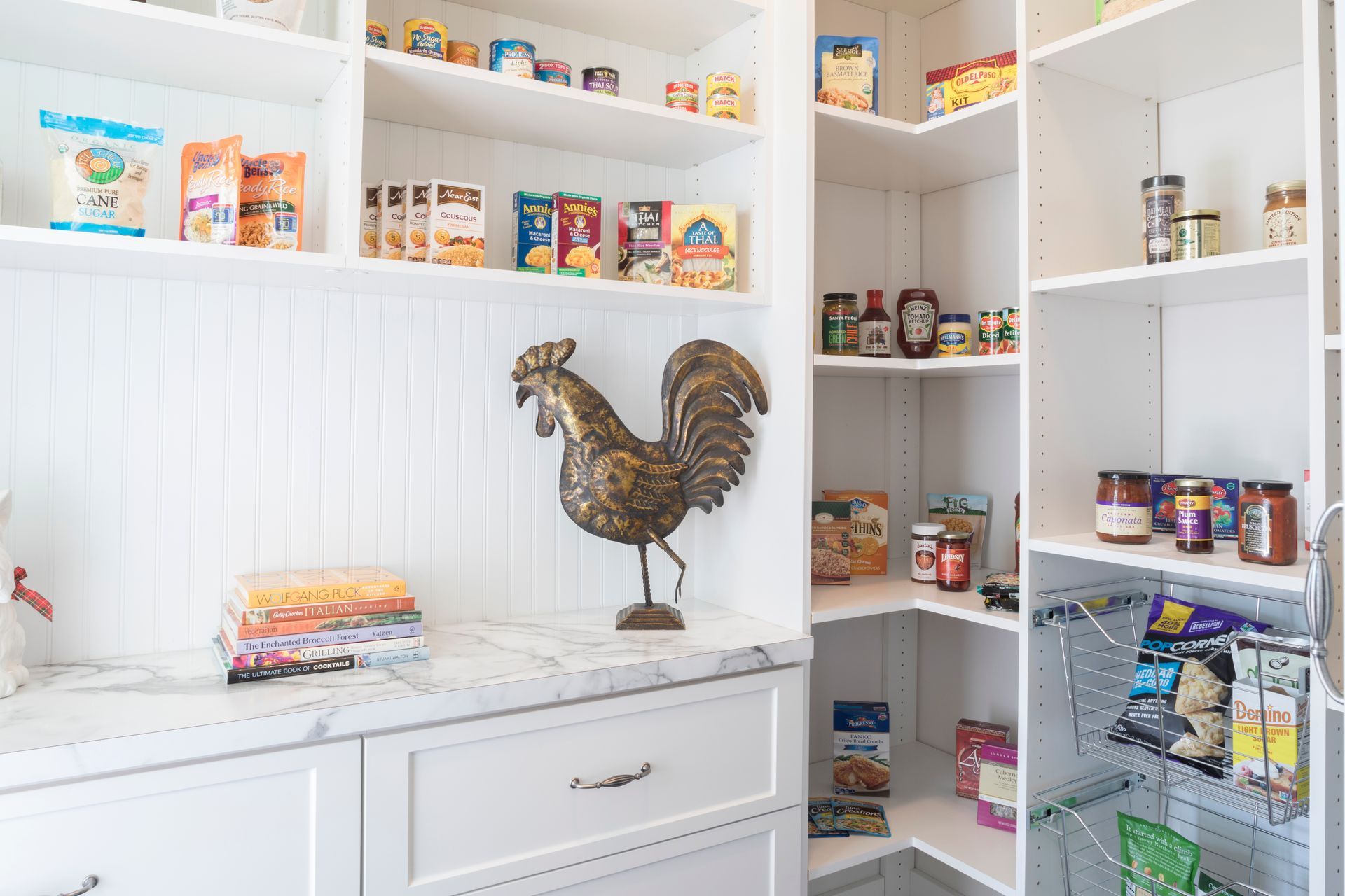 A pantry with a statue of a rooster on the wall.