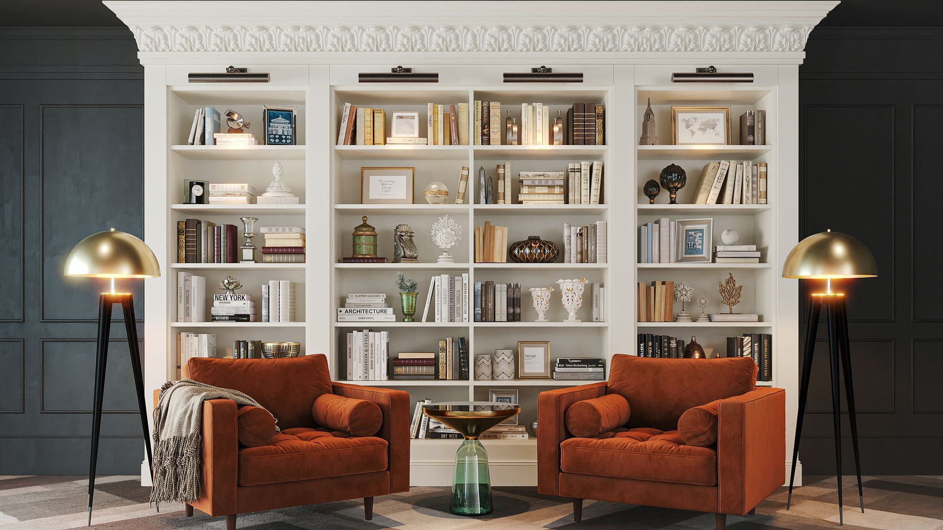 Two orange armchairs face a white bookcase filled with books and decor. Two gold lamps flank the chairs.