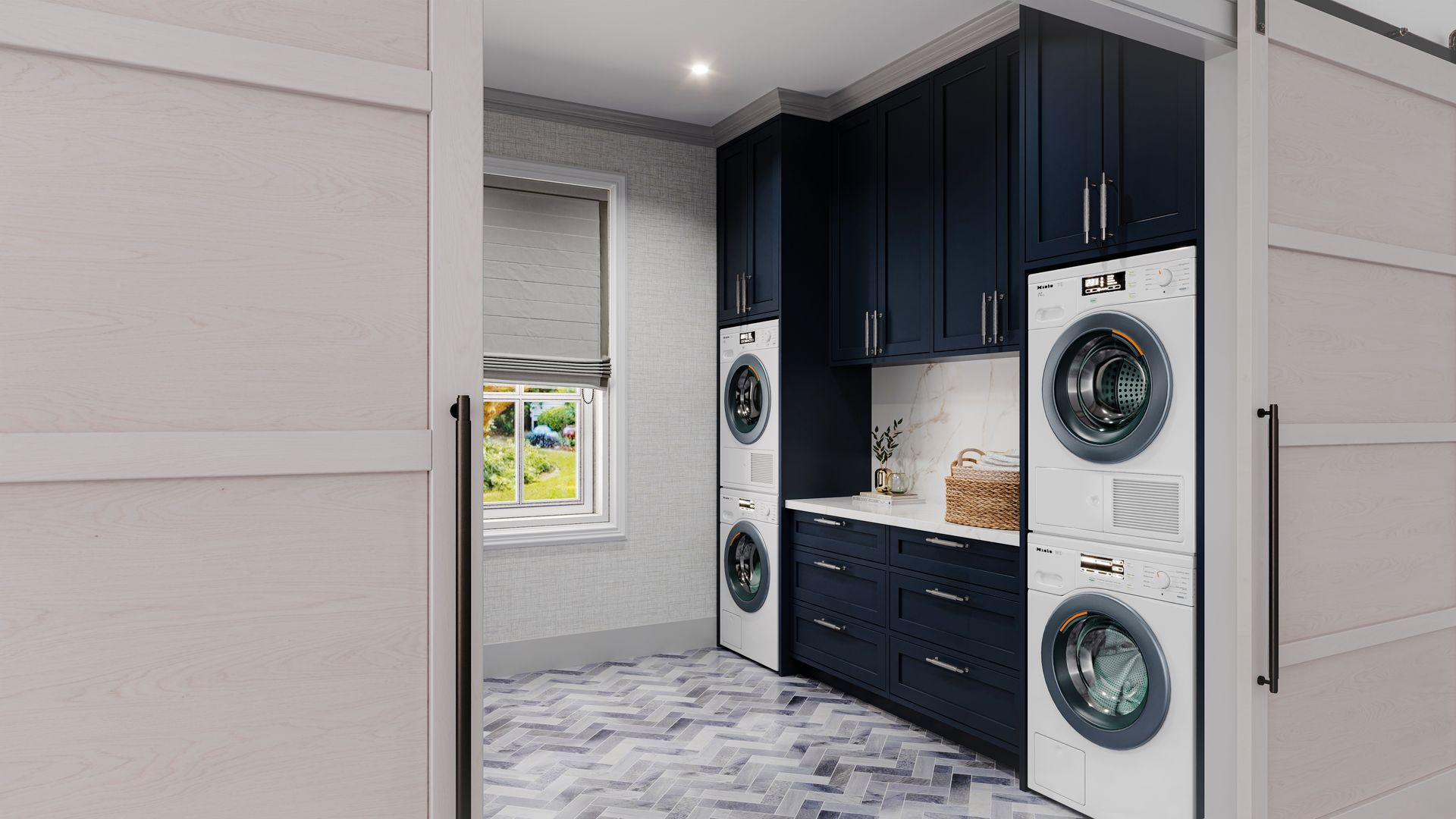 A laundry room with dark blue cabinets, stacked washer and dryer units, and a herringbone patterned floor. Sliding doors are partially open.