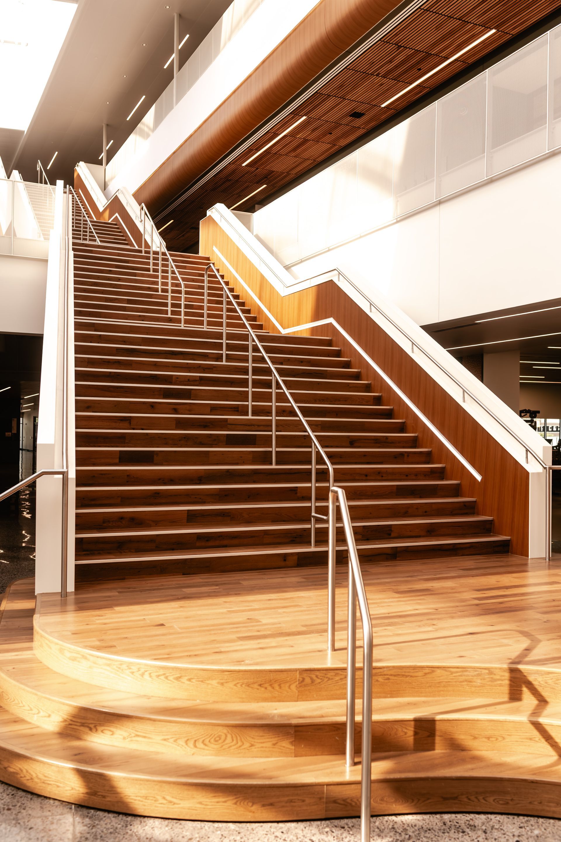 Wooden staircase with metal handrails in a bright modern interior lobby