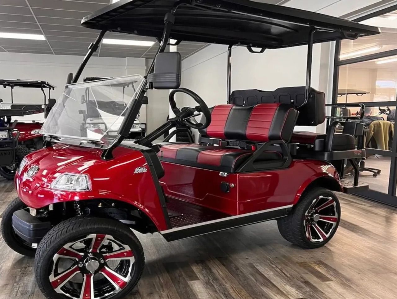 A red golf cart is parked in a showroom