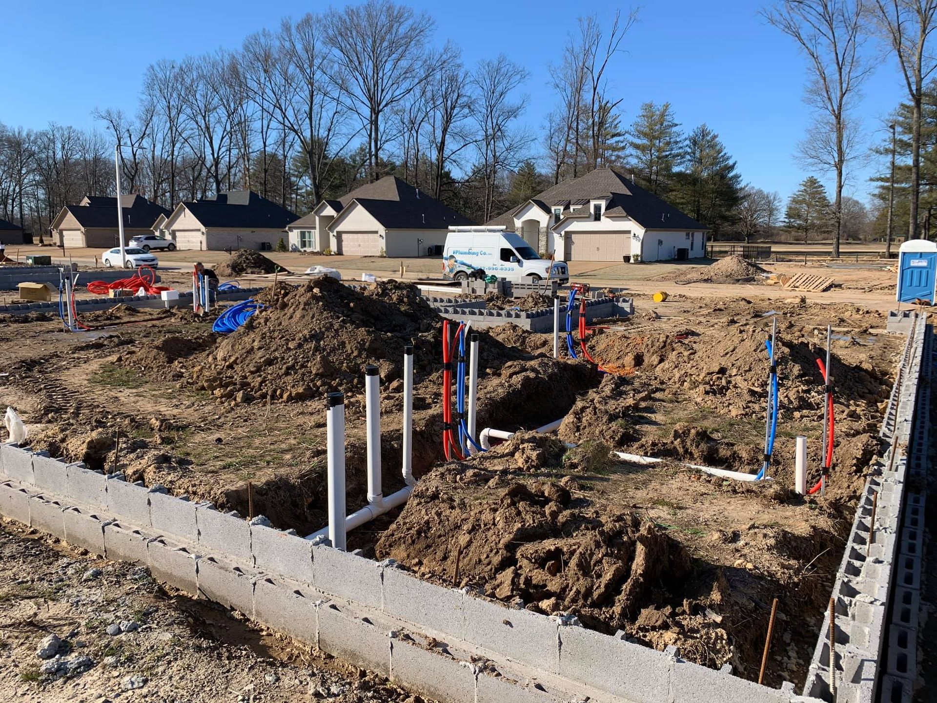 A construction site with a lot of pipes in the dirt.