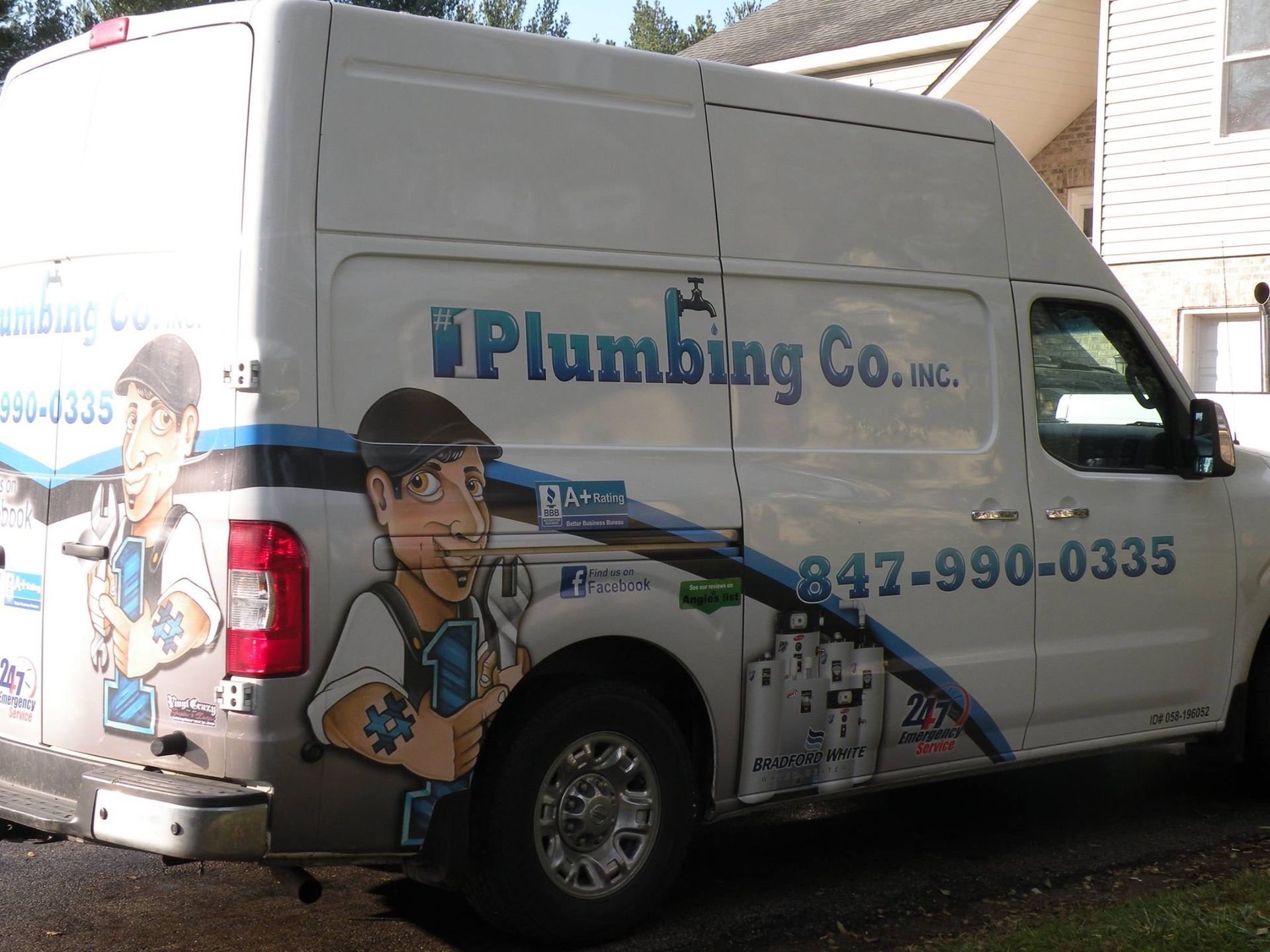 A plumbing company van is parked in front of a house