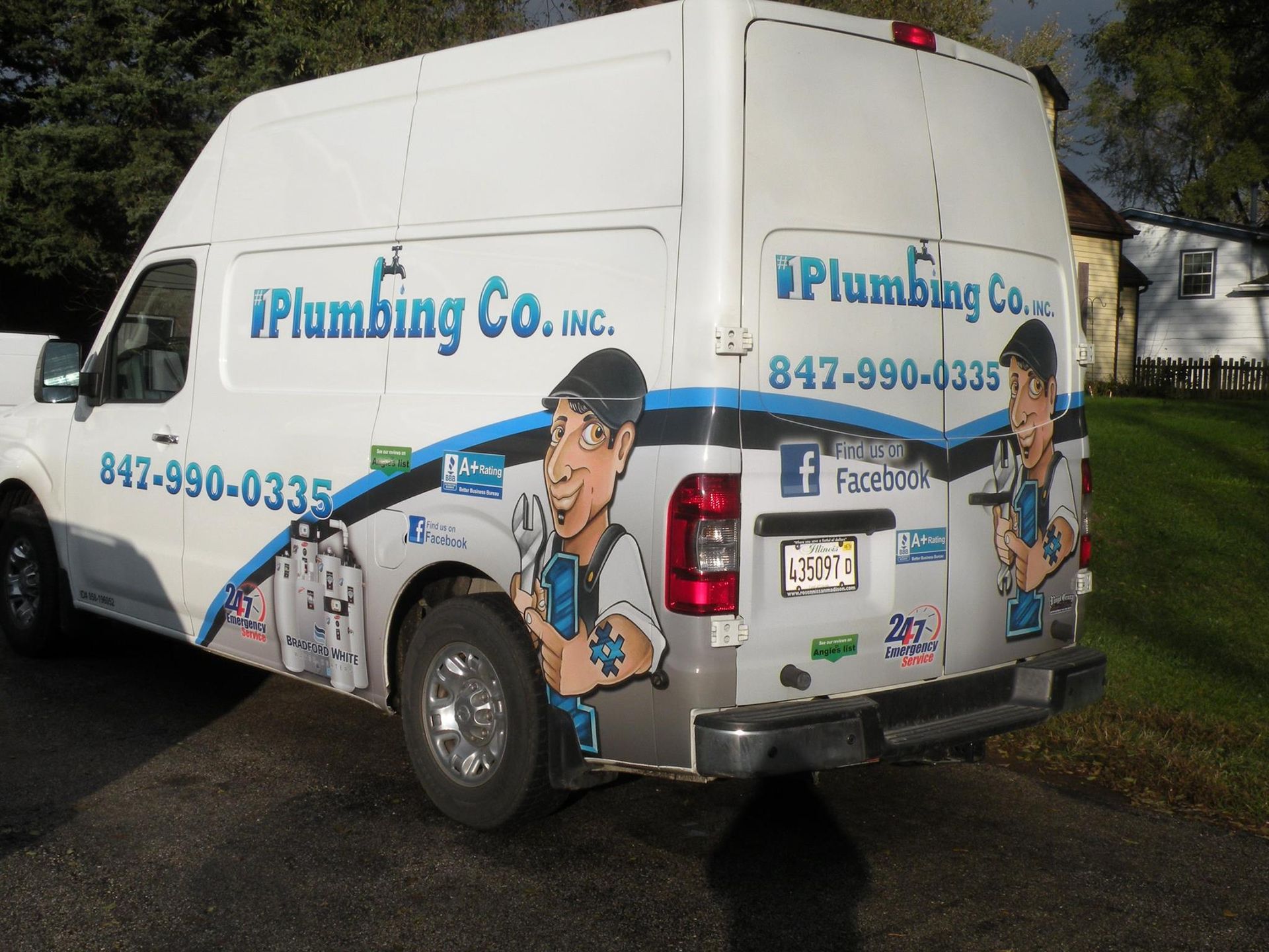 A plumbing company van is parked in a driveway