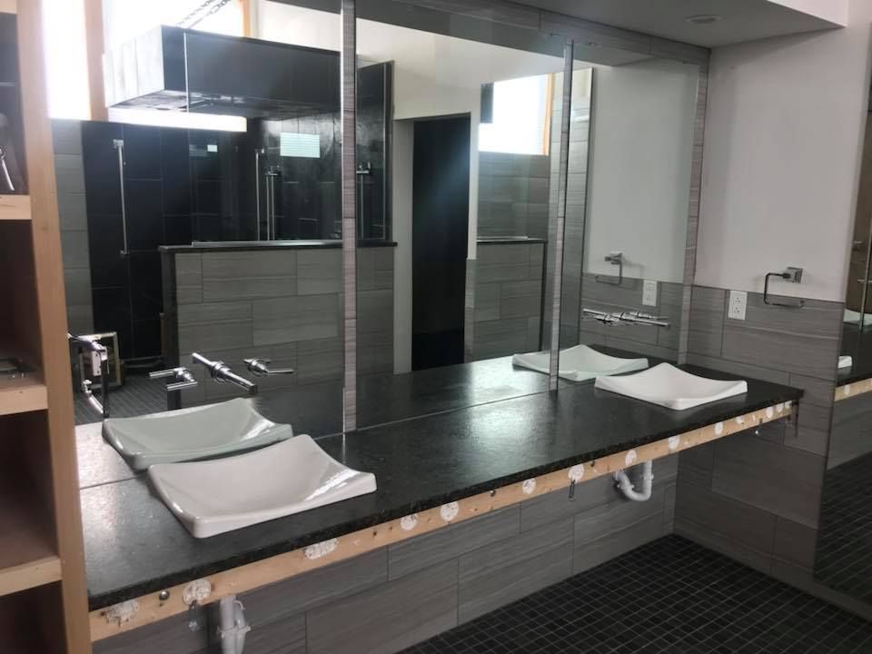 A bathroom with two sinks and a large mirror.