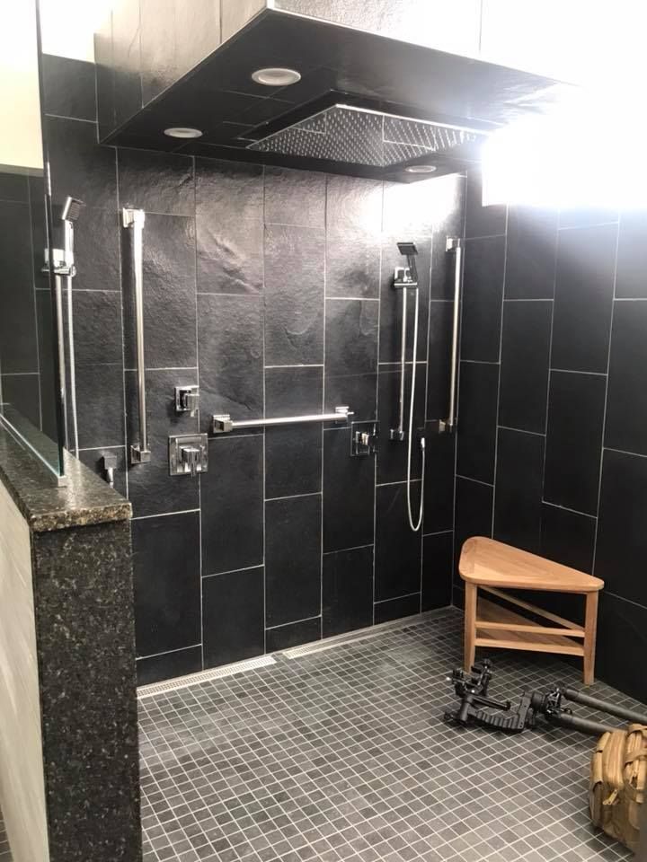 A bathroom with a walk in shower and a bench.