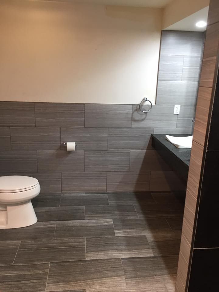 A bathroom with a toilet , sink and mirror.