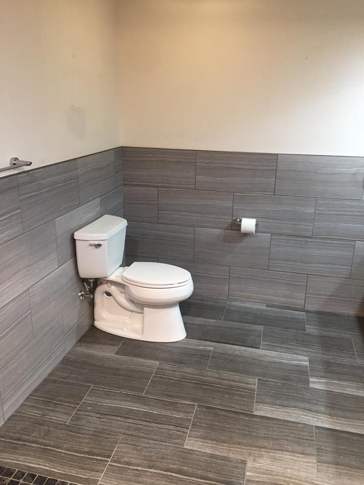 A bathroom with a toilet and a paper towel dispenser.