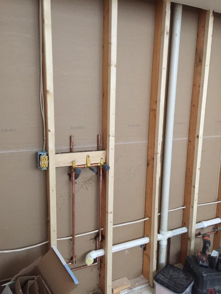 A wall with a lot of pipes coming out of it.