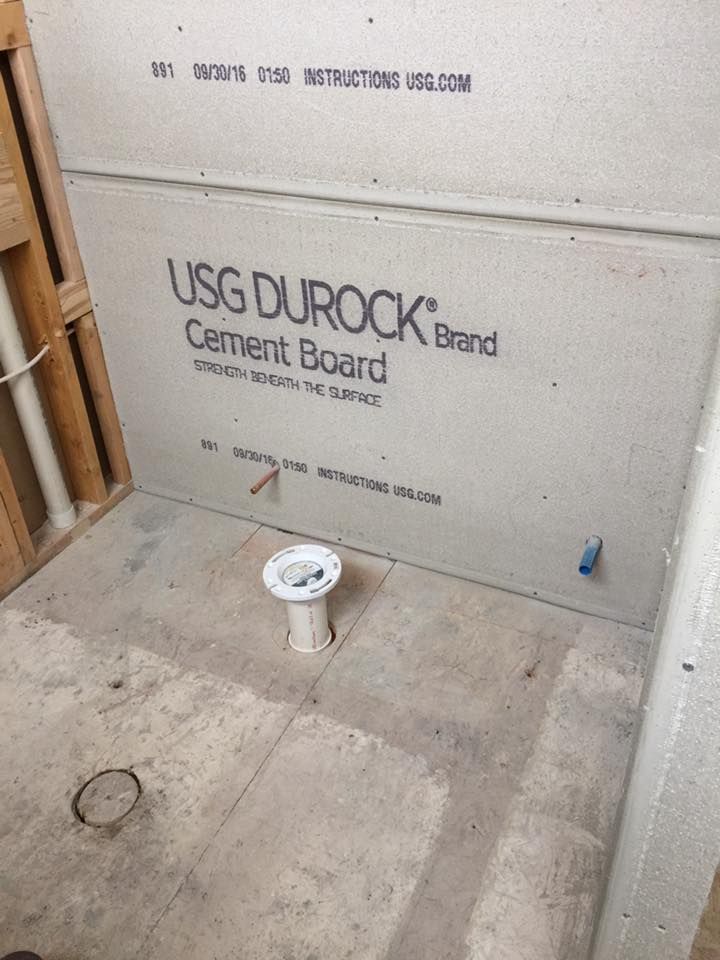 A bathroom under construction with a usg durock cement board on the wall