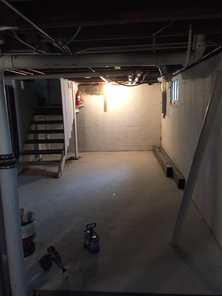 A basement with stairs and a light on the ceiling.