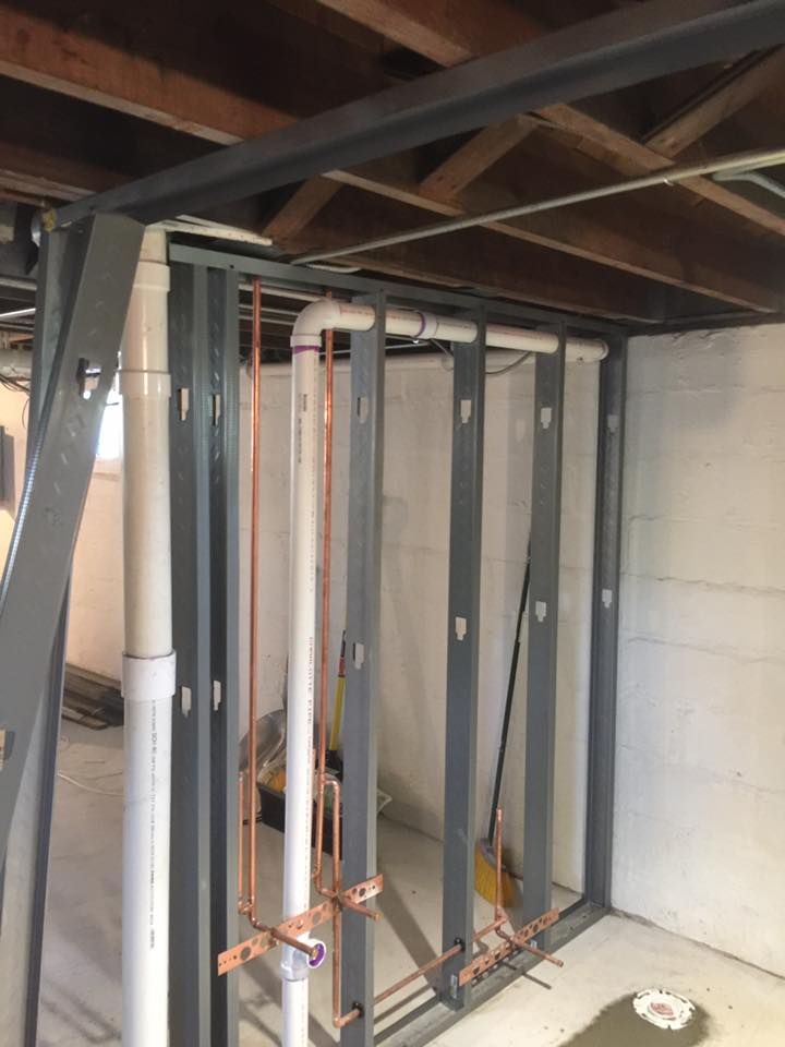 A room with a lot of pipes hanging from the ceiling.