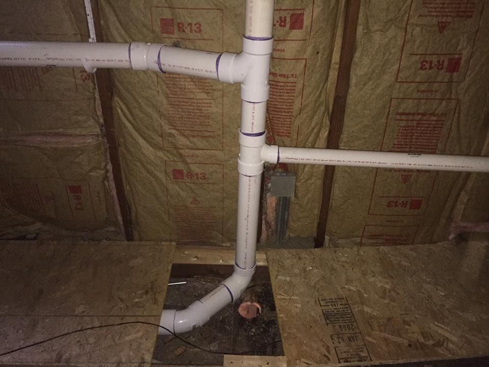 A man is standing in a room with a lot of pipes.