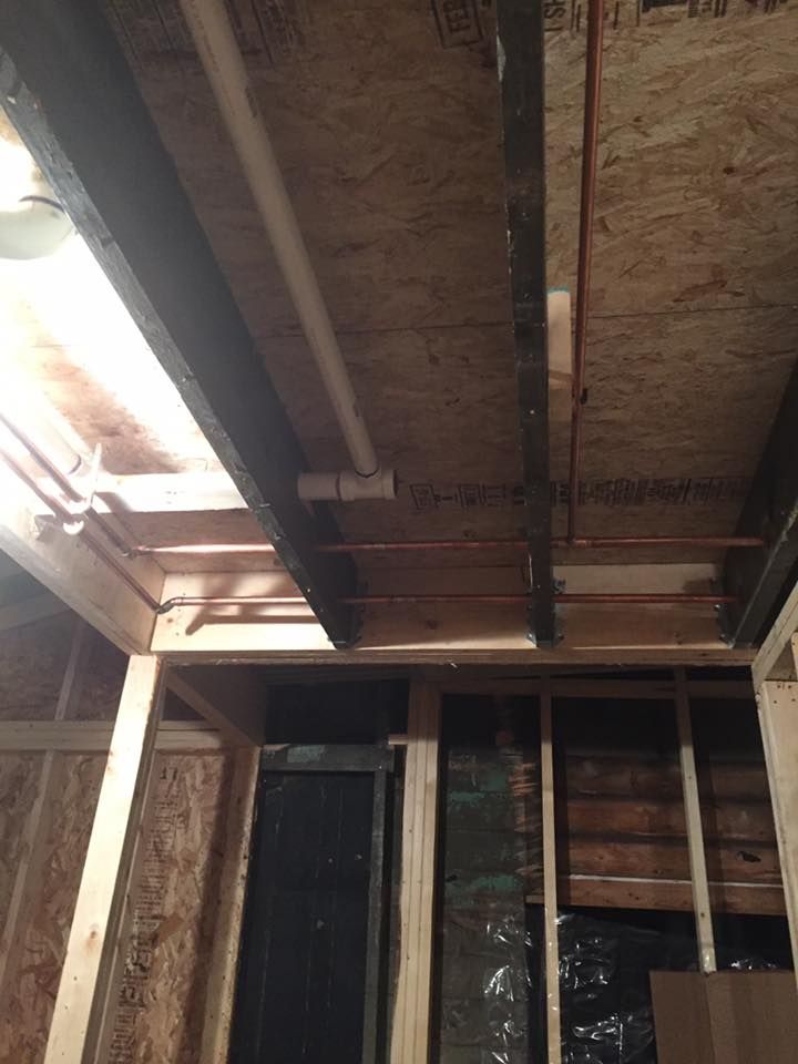 A wooden ceiling with pipes hanging from it