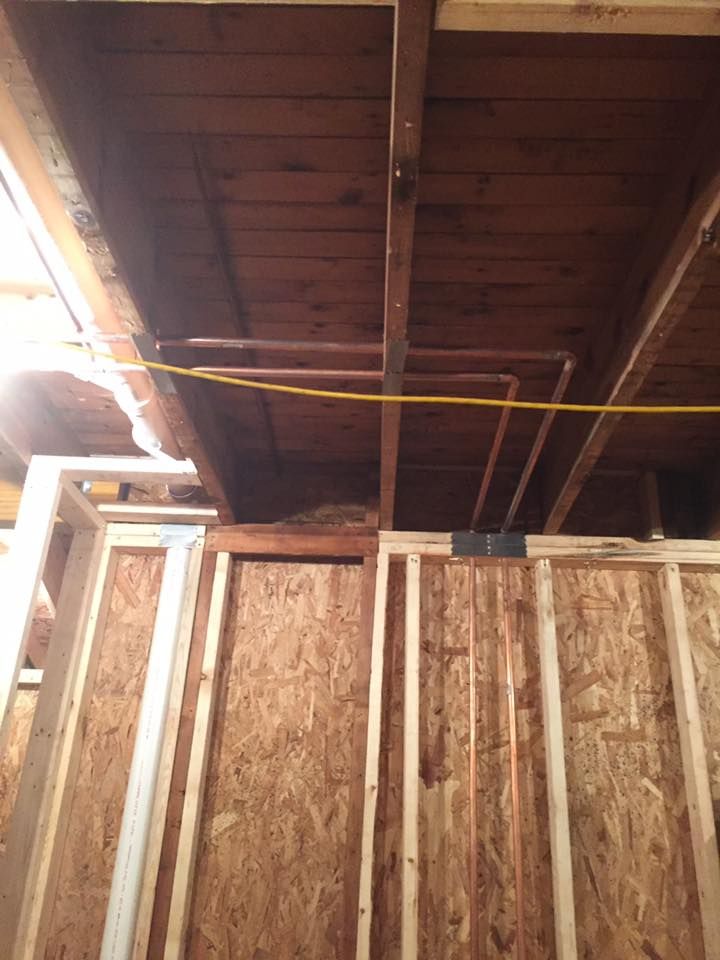A wooden ceiling with pipes coming out of it