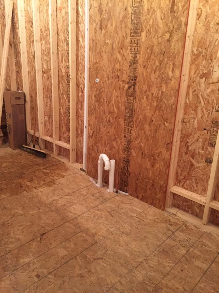 A room with wooden walls and tile floors under construction.