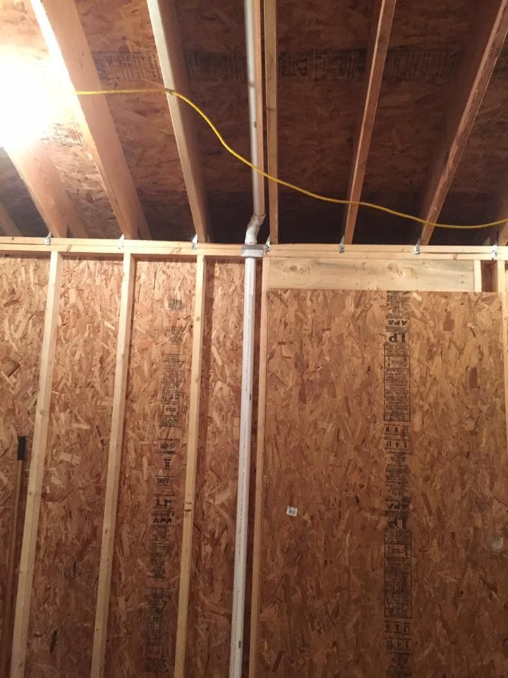 A wooden wall with a pipe coming out of it.