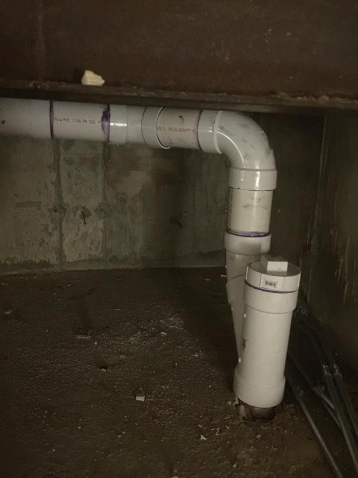A bunch of white pipes are connected to each other in a room.