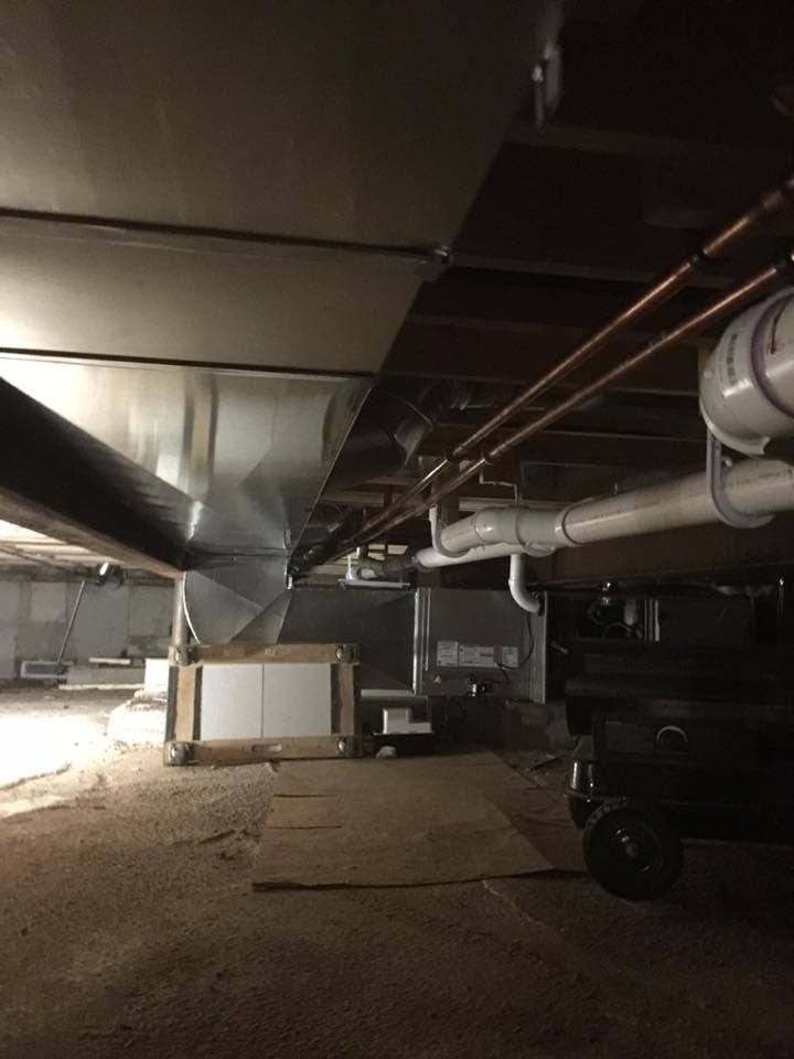 A basement with a lot of pipes coming out of the ceiling.