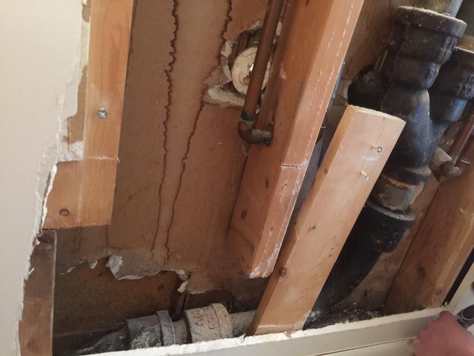 A hole in a wall with pipes coming out of it.