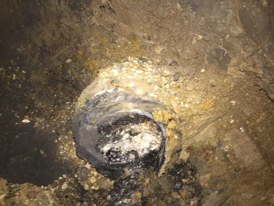 A close up of a hole in the ground filled with dirt and rocks.