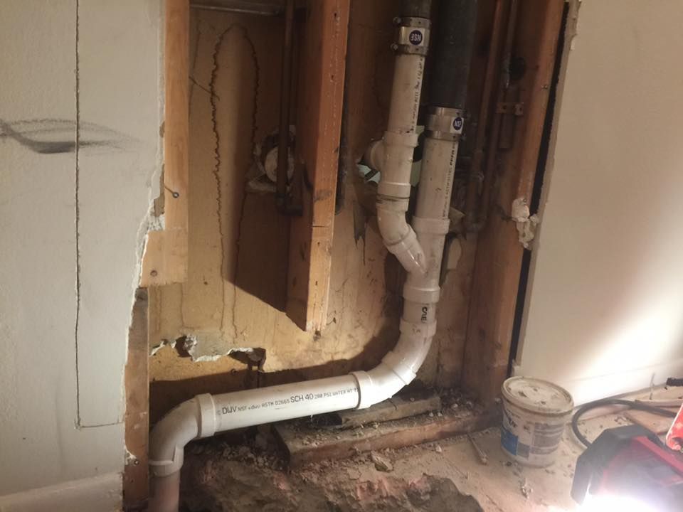 A room with a hole in the wall and a pipe coming out of it.