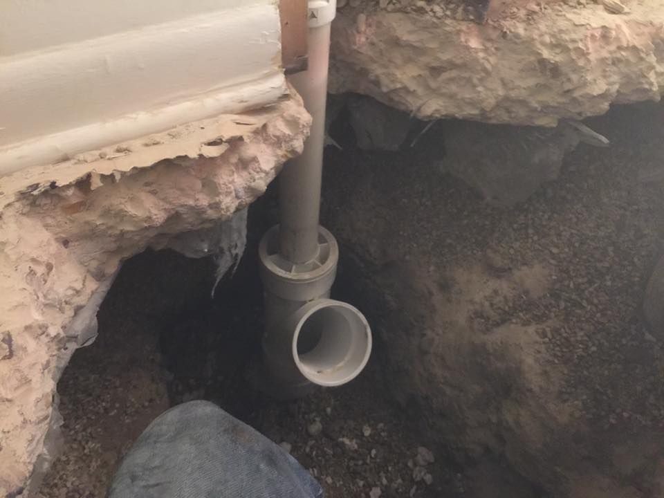 A pipe is being installed in a hole in the ground.