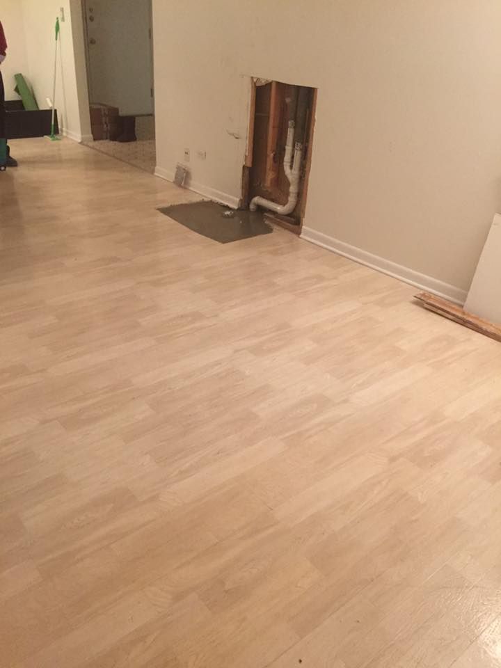 A room with a wooden floor and a hole in the wall.