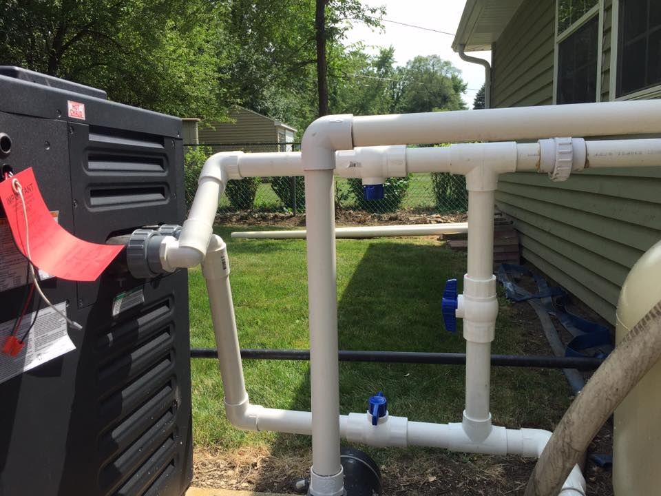 A hose is attached to a pipe in front of a house