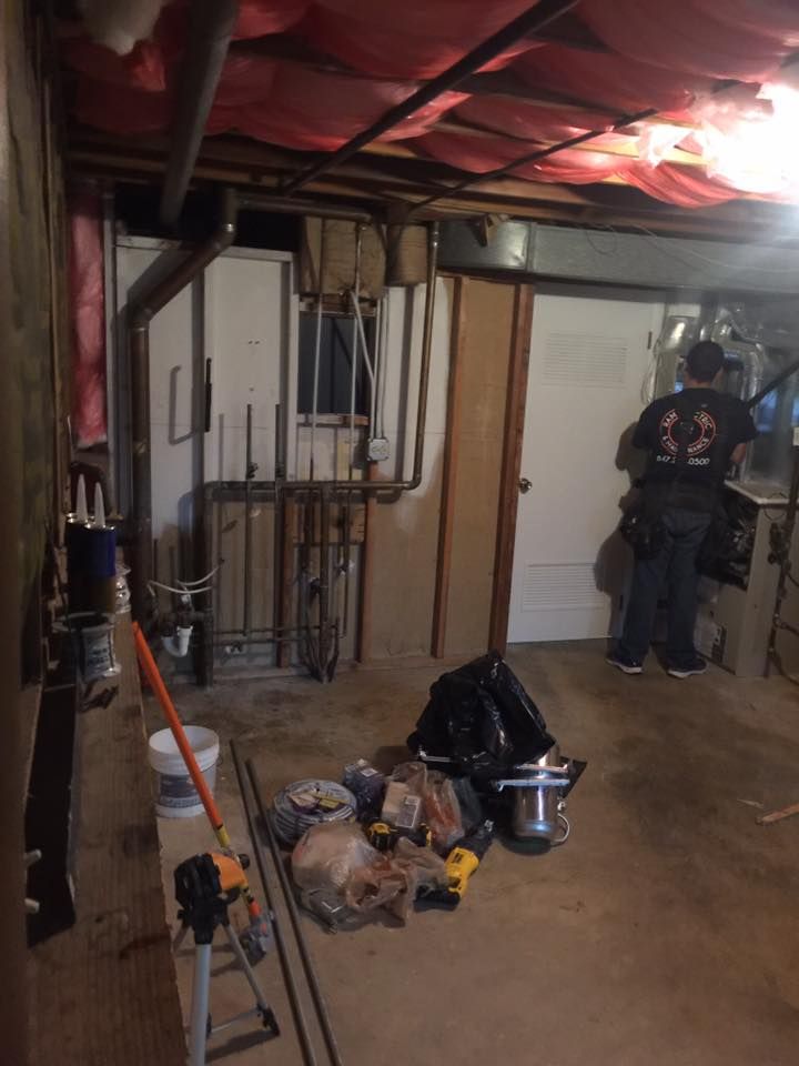 A man is standing in a basement with a lot of tools.