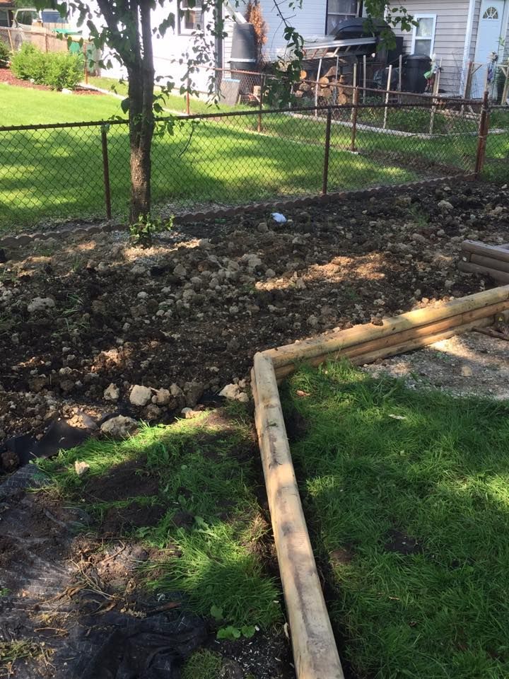 A wooden fence is being built in the backyard of a house.