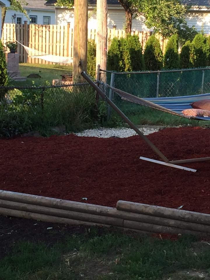 A hammock is sitting on top of a pile of red mulch