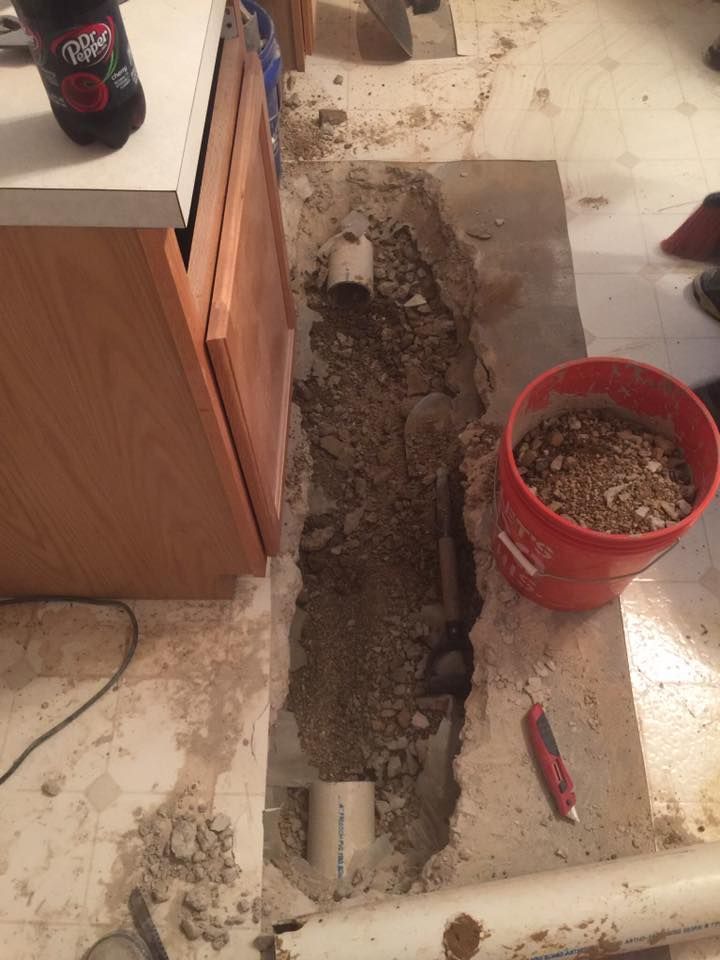 A bucket of dirt is on the floor next to a hole in the floor.