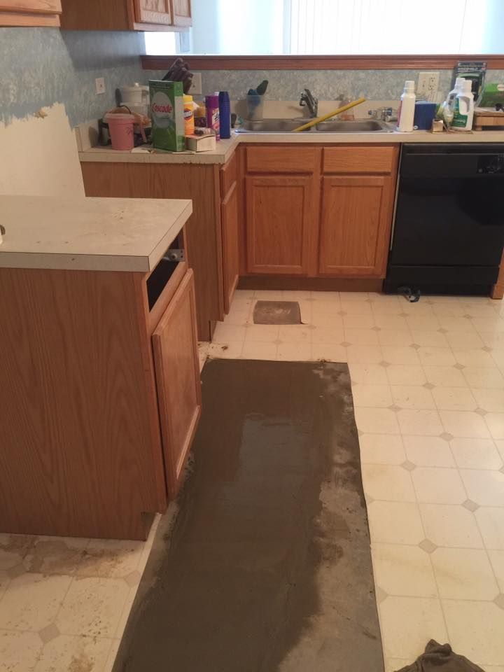A kitchen with wooden cabinets and a black dishwasher.