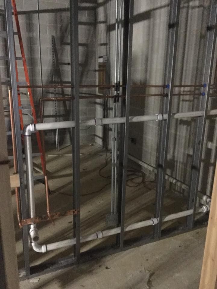 A room under construction with pipes and a ladder.