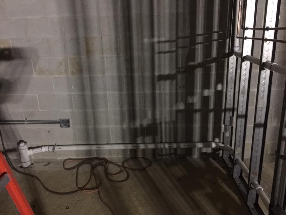 A room with pipes and a ladder in it