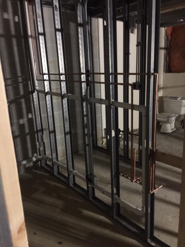 A bathroom under construction with a toilet and pipes