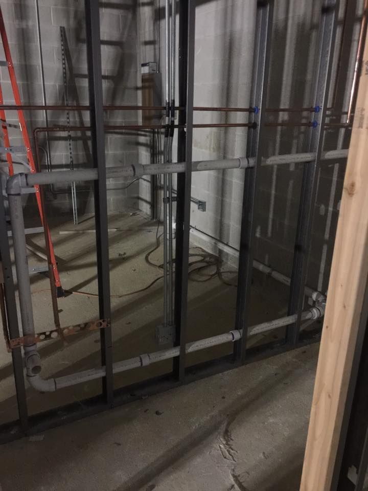 A building under construction with a ladder in the background.