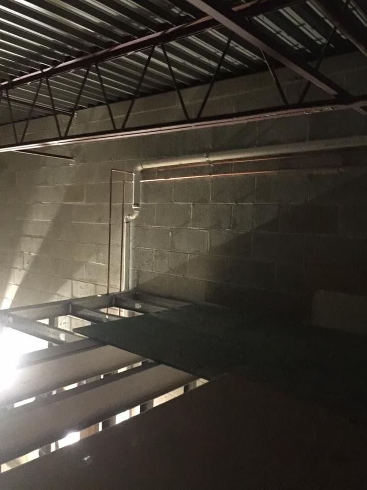 A dark room with a metal ceiling and brick walls.